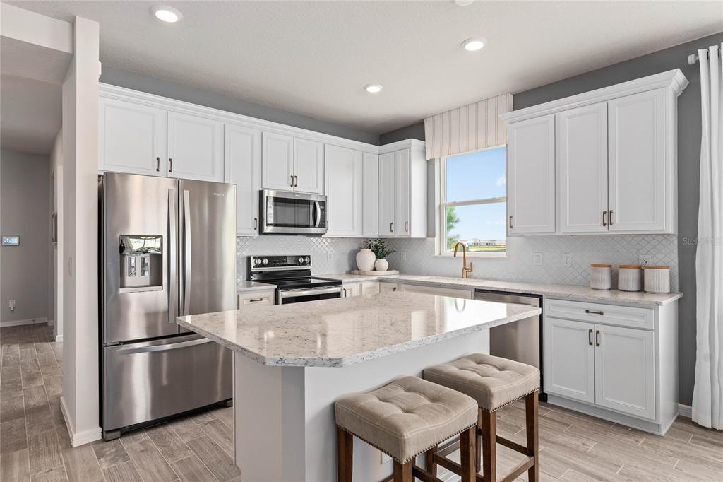 6300 Dew Drop Loop St. Cloud, FL 34771 - Photo 5 of 29 a kitchen with a refrigerator a stove a sink and chairs