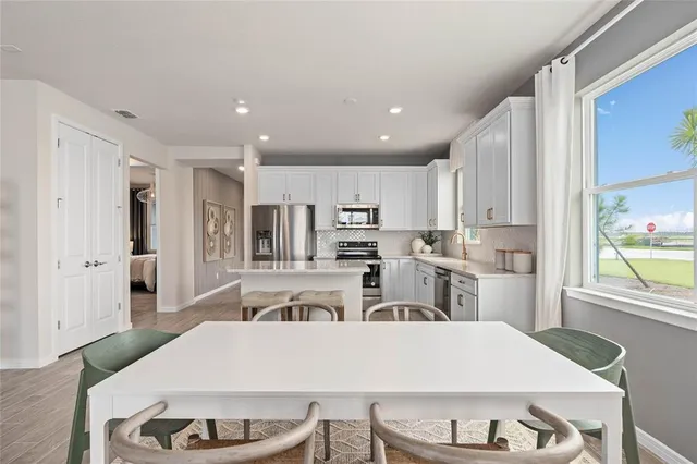 a large white kitchen with sink and refrigerator