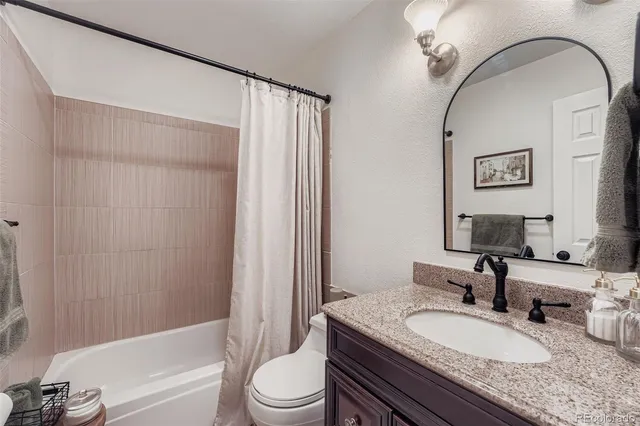a bathroom with a granite countertop sink toilet and shower