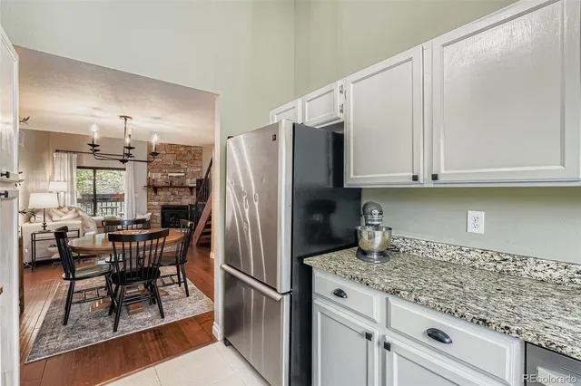 a kitchen with stainless steel appliances granite countertop a refrigerator and wooden cabinets