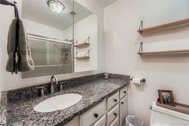 a bathroom with a granite countertop sink and a mirror