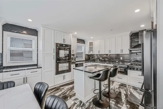 a kitchen with a sink stainless steel appliances cabinets and a counter top space