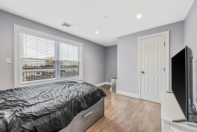 a spacious bedroom with a bed a couch and a window