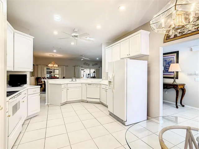 a kitchen with stainless steel appliances granite countertop white cabinets and a stove a oven with white countertops
