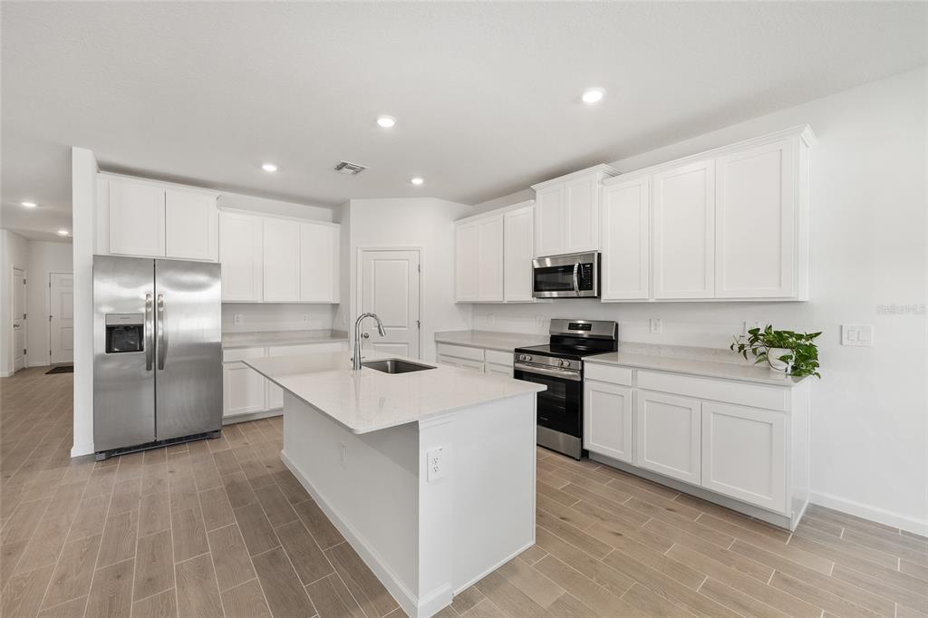 8972 Southwest 69th Terrace Ocala, FL 34476 - Photo 11 of 42 a kitchen with white cabinets stainless steel appliances and sink