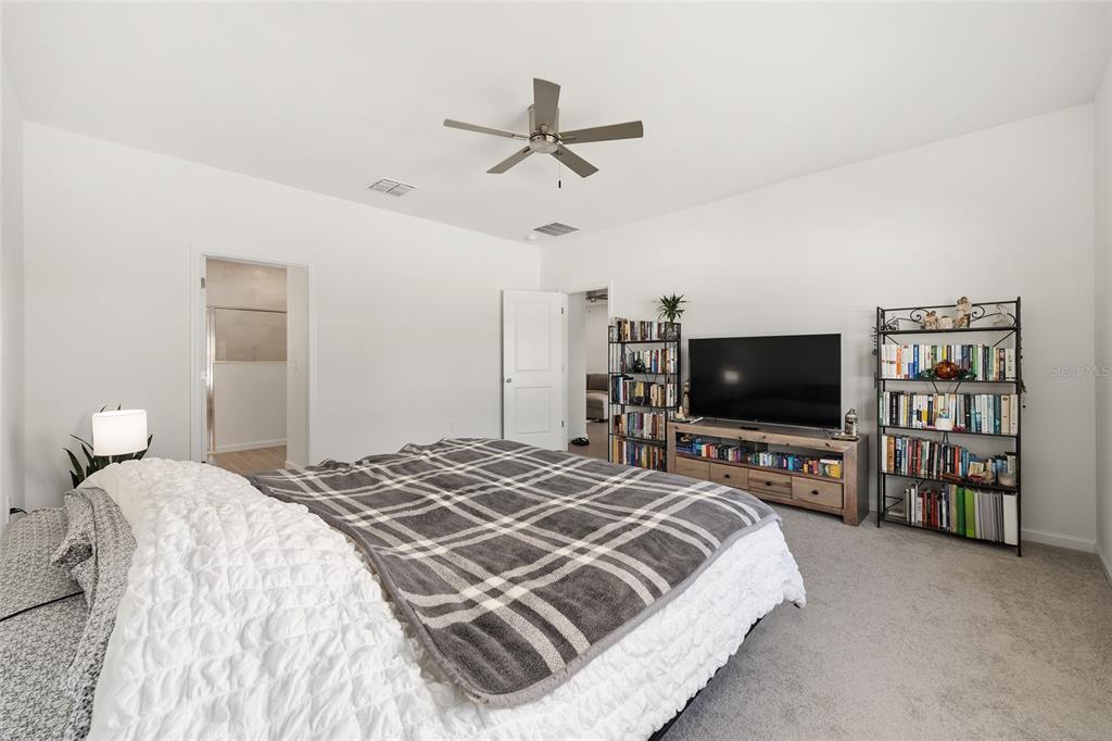 8972 Southwest 69th Terrace Ocala, FL 34476 - Photo 19 of 42 a bedroom with a bed and a flat screen tv