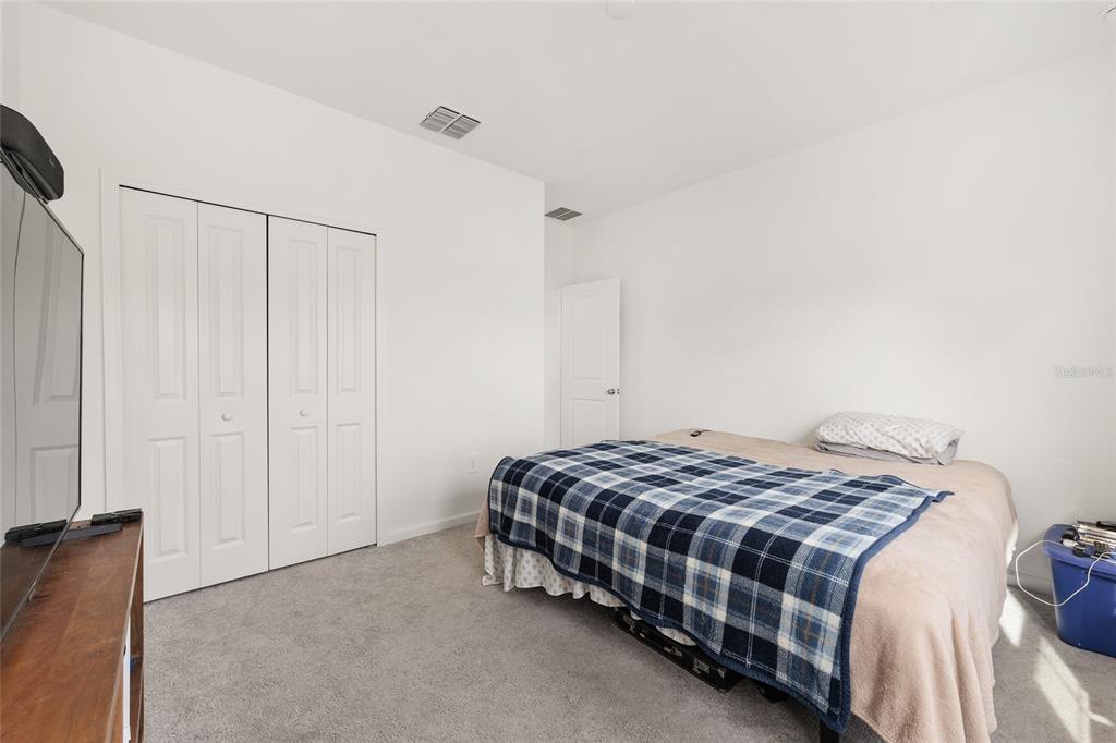 8972 Southwest 69th Terrace Ocala, FL 34476 - Photo 24 of 42 a bedroom with a bed and a cabinets