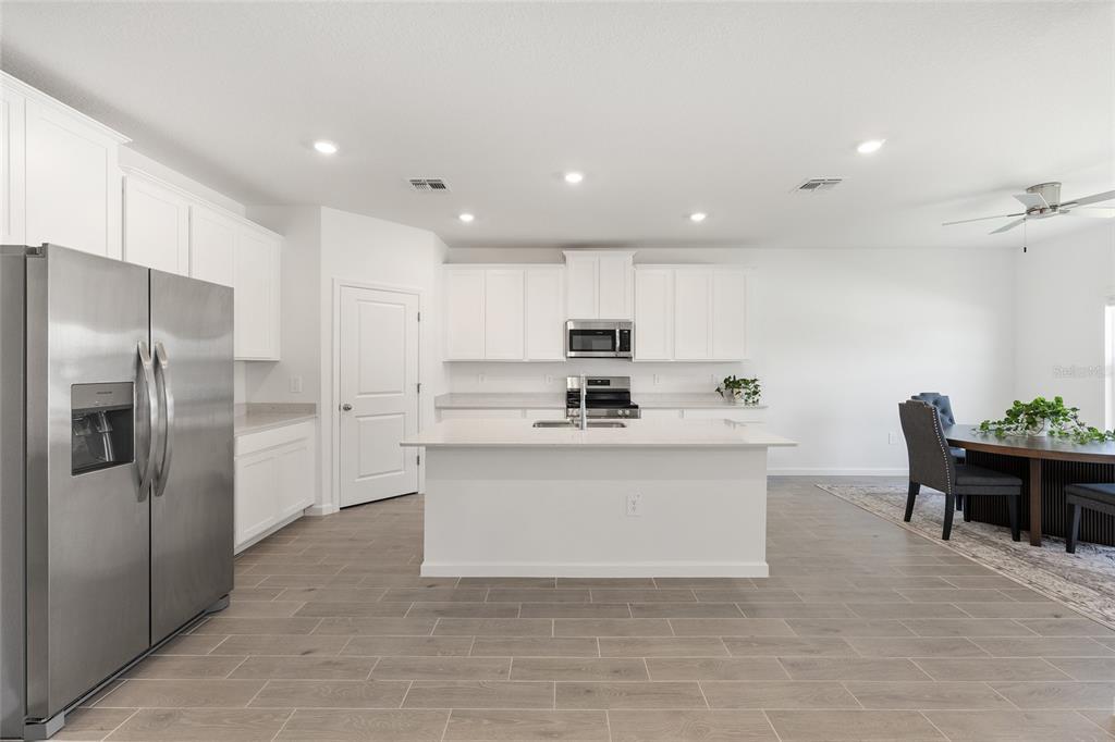 8972 Southwest 69th Terrace Ocala, FL 34476 - Photo 10 of 42 a kitchen with stainless steel appliances a refrigerator sink and white cabinets