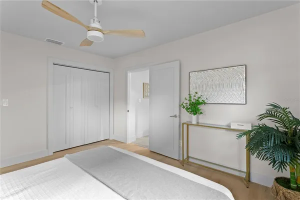 a spacious bedroom with a bed and a chandelier