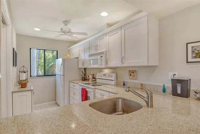 a kitchen with cabinets appliances a sink and a counter top space