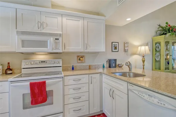 a kitchen with stainless steel appliances granite countertop a sink and cabinets