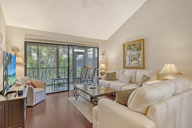 a living room with furniture floor to ceiling window and a flat screen tv