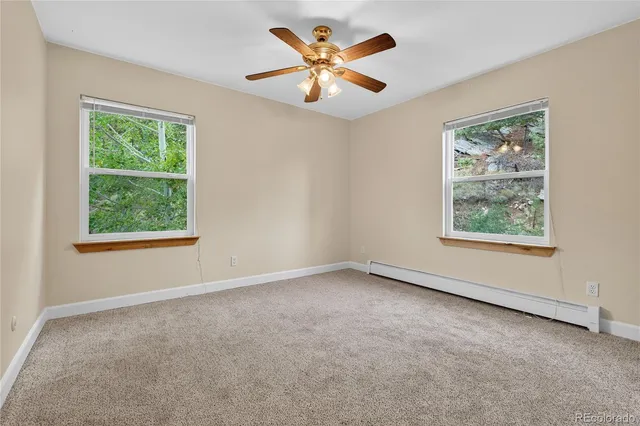 an empty room with a window and a fan