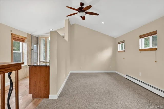 an empty room with windows and a ceiling fan