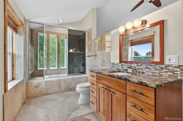 a bathroom with a granite countertop sink toilet and mirror