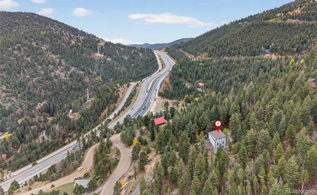 a view of a house with a mountain and a forest