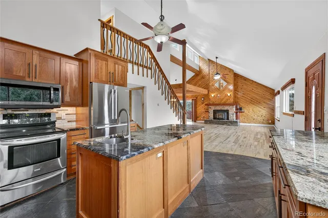 a kitchen with stainless steel appliances granite countertop a sink a stove and a refrigerator