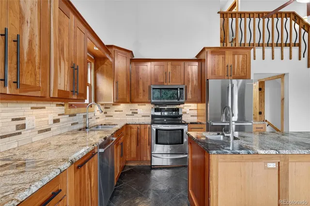 a kitchen with stainless steel appliances granite countertop a sink stove and refrigerator