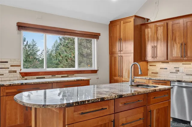 a kitchen with granite countertop a sink and a window
