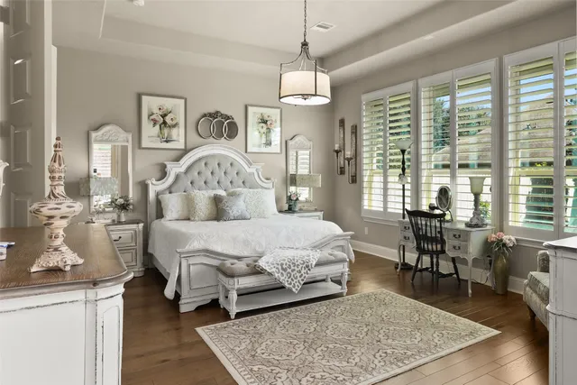 a bedroom with a large bed a chandelier and a window