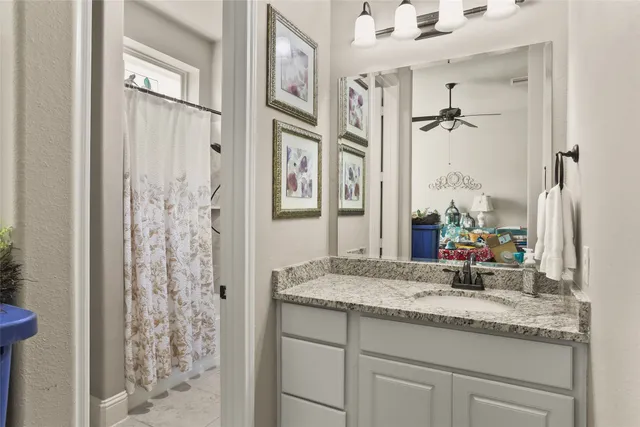 a bathroom with a granite countertop sink and a mirror