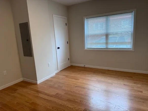 a view of an empty room with wooden floor
