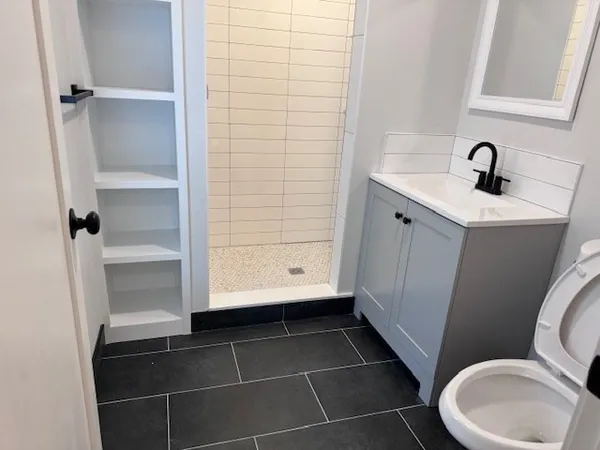 a bathroom with a sink a toilet and shower