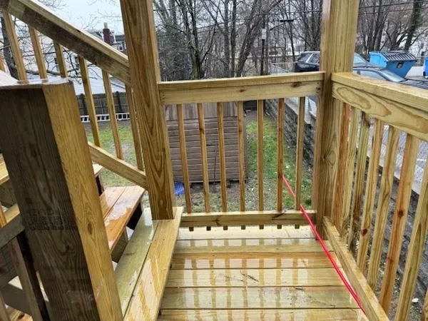 a view of balcony with wooden floor and fence