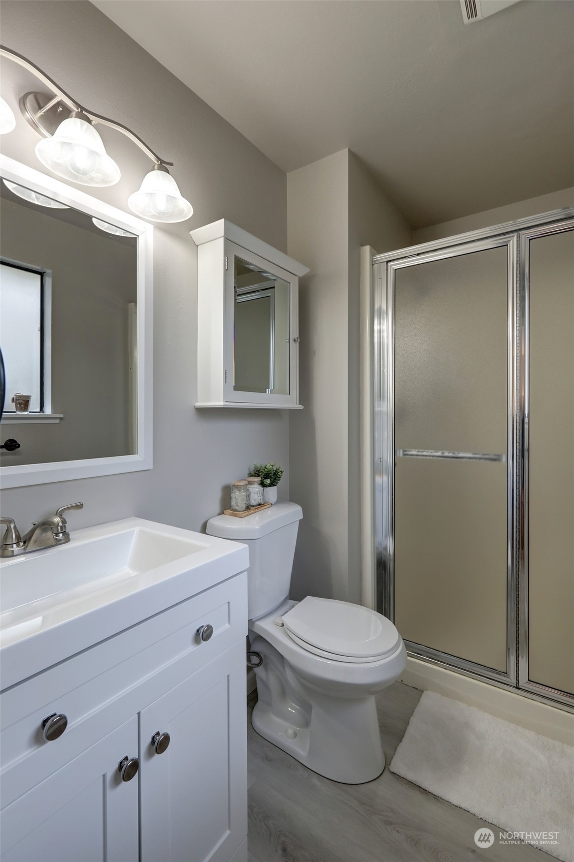 12404 Southeast 227th Street Kent, WA 98031 - Photo 11 of 21 a bathroom with a toilet a sink a mirror and a shower