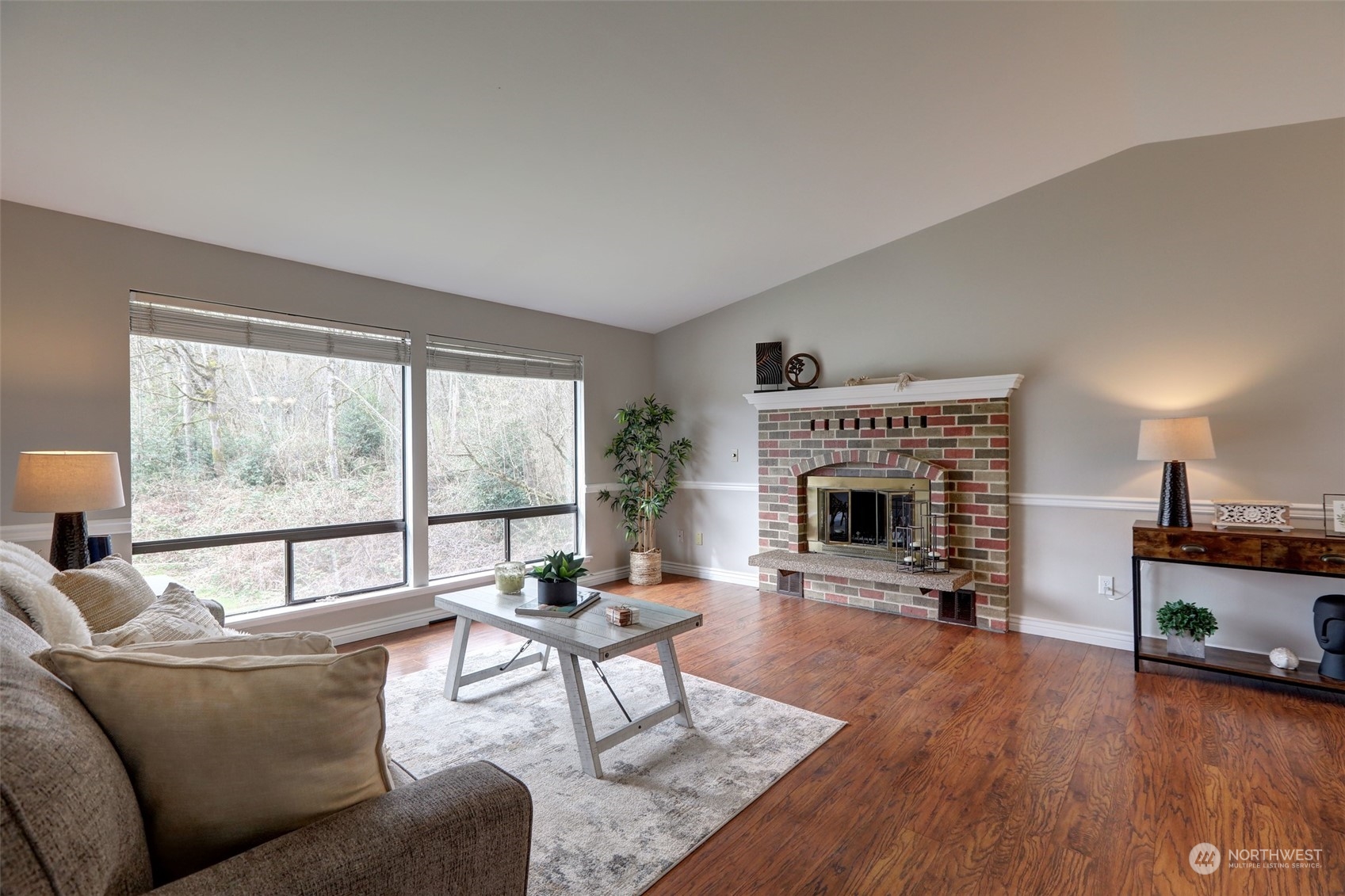 12404 Southeast 227th Street Kent, WA 98031 - Photo 2 of 21 a living room with furniture a fireplace and a floor to ceiling window