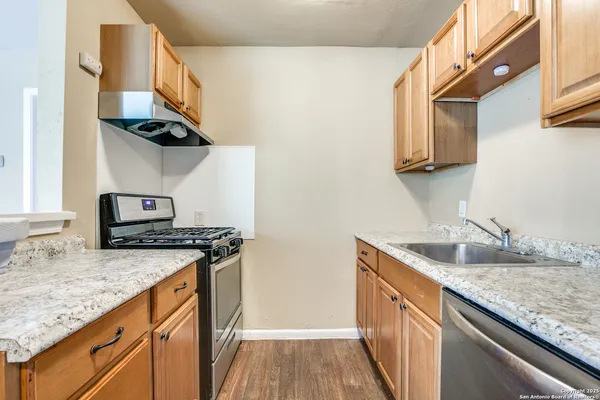 a kitchen with stainless steel appliances granite countertop a sink stove and cabinets