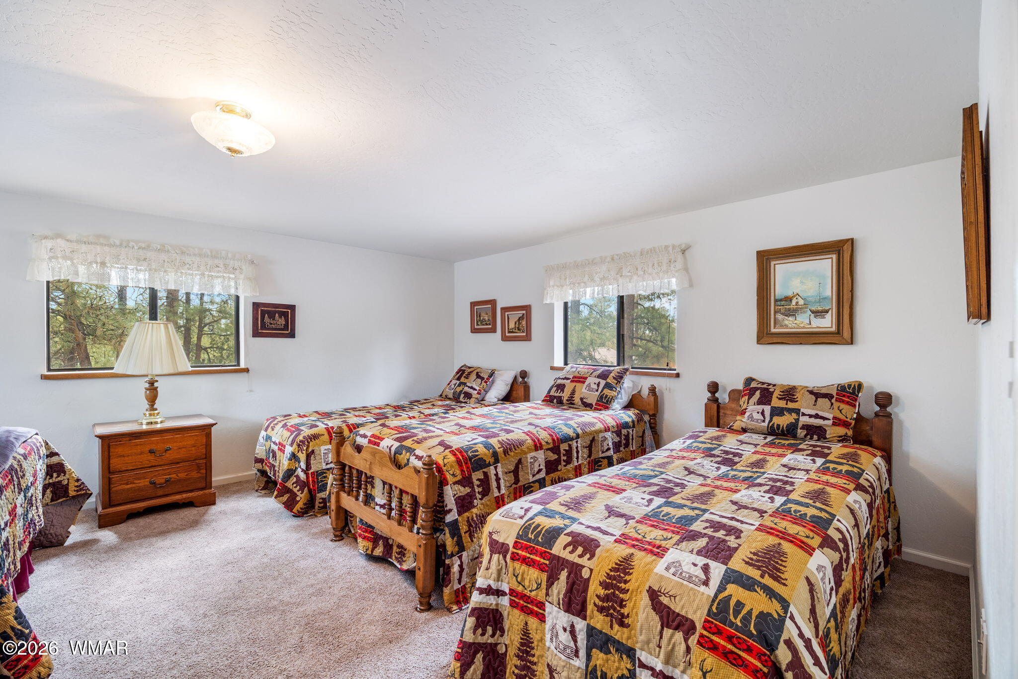 2922 Pine Rim Road Overgaard, AZ 85933 - Photo 36 of 58 a bedroom with two beds and a lamp on dresser