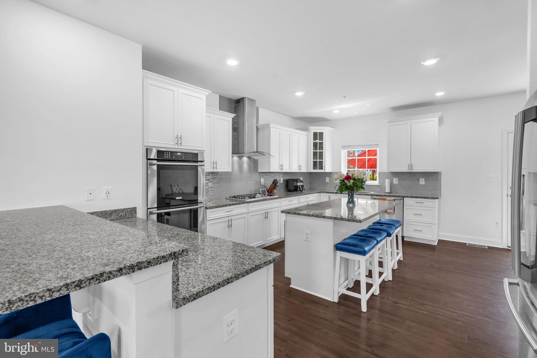5007 East Joppa Road Perry Hall, MD 21128 - Photo 6 of 28 a kitchen with stainless steel appliances granite countertop a sink dishwasher a stove refrigerator and cabinets with wooden floor