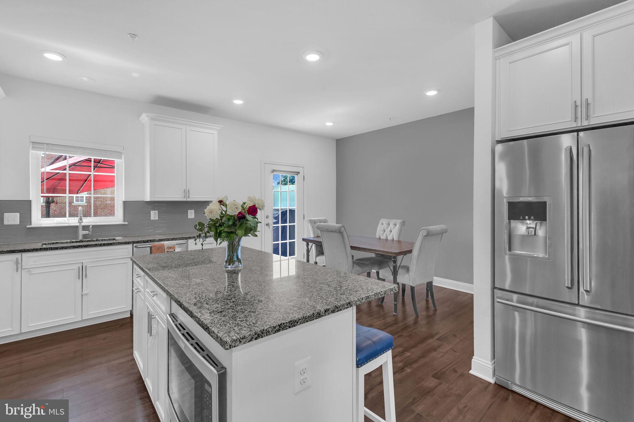 5007 East Joppa Road Perry Hall, MD 21128 - Photo 10 of 28 a kitchen with stainless steel appliances granite countertop a refrigerator a sink a stove a dining table and chairs