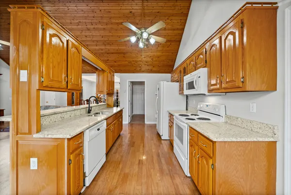 a large kitchen with stainless steel appliances granite countertop a sink and cabinets