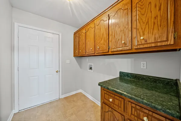 a kitchen with granite countertop cabinets and utility room