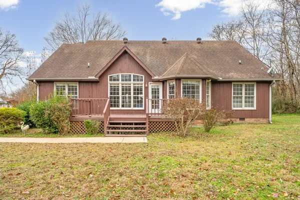 a front view of house with yard and trees in the background