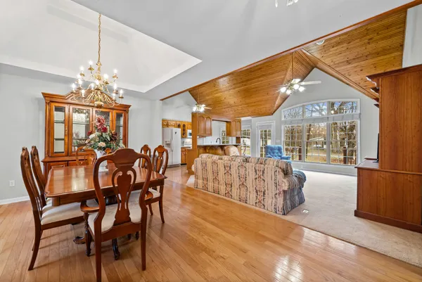 a view of a dining room and livingroom with furniture large window and wooden floor