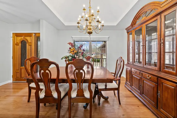 a view of a dining room with furniture a chandelier and wooden floor