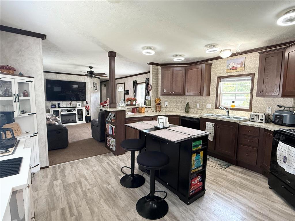 49 Ritz Craft Street Walnutport, PA 18088 - Photo 2 of 11 An open concept kitchen features warm wooden cabinetry, modern appliances, and a convenient island with seating.