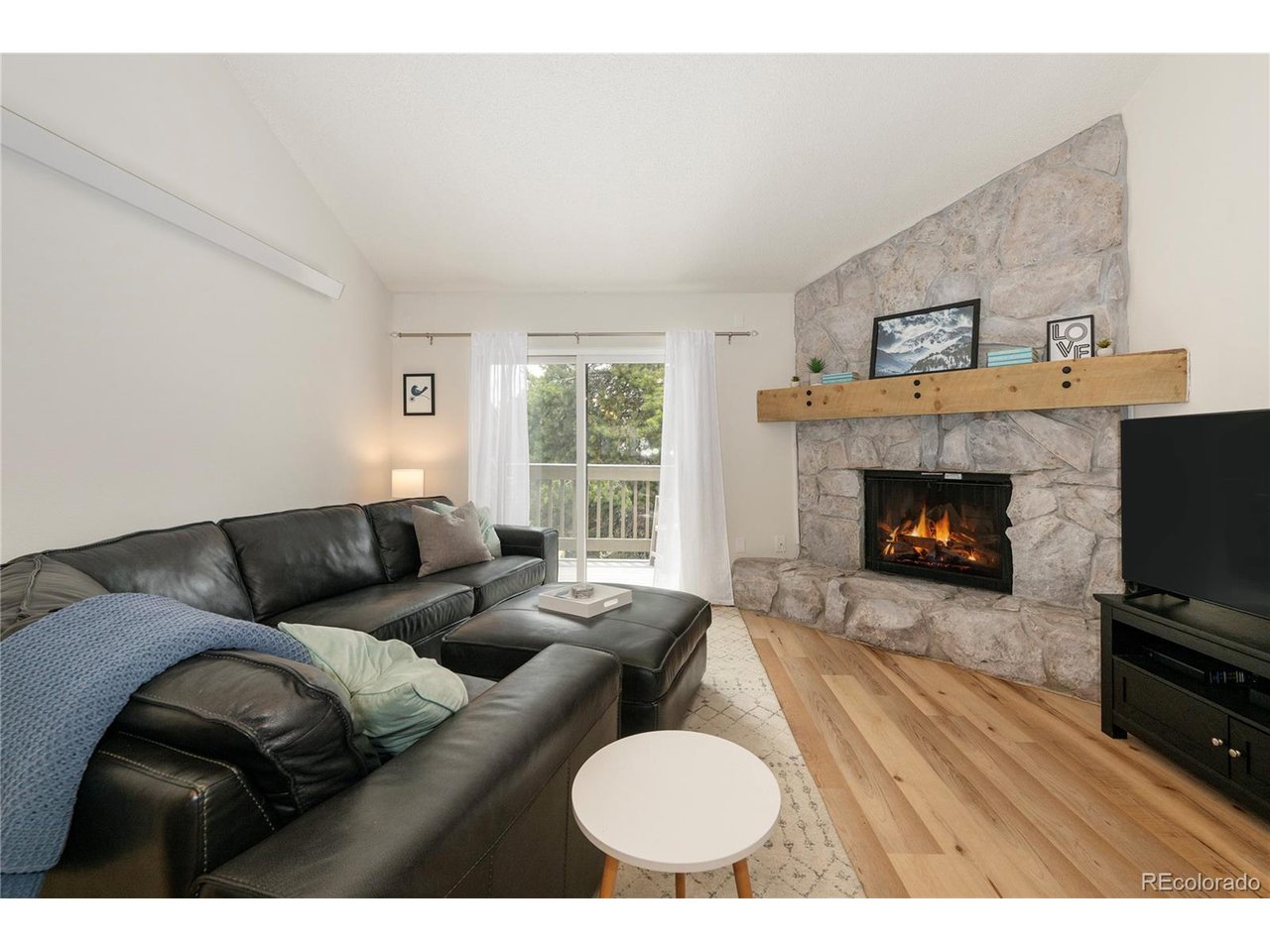 62 County Road 838, Unit 4 Fraser, CO 80442 - Photo 2 of 39 a living room with furniture a fireplace and a flat screen tv