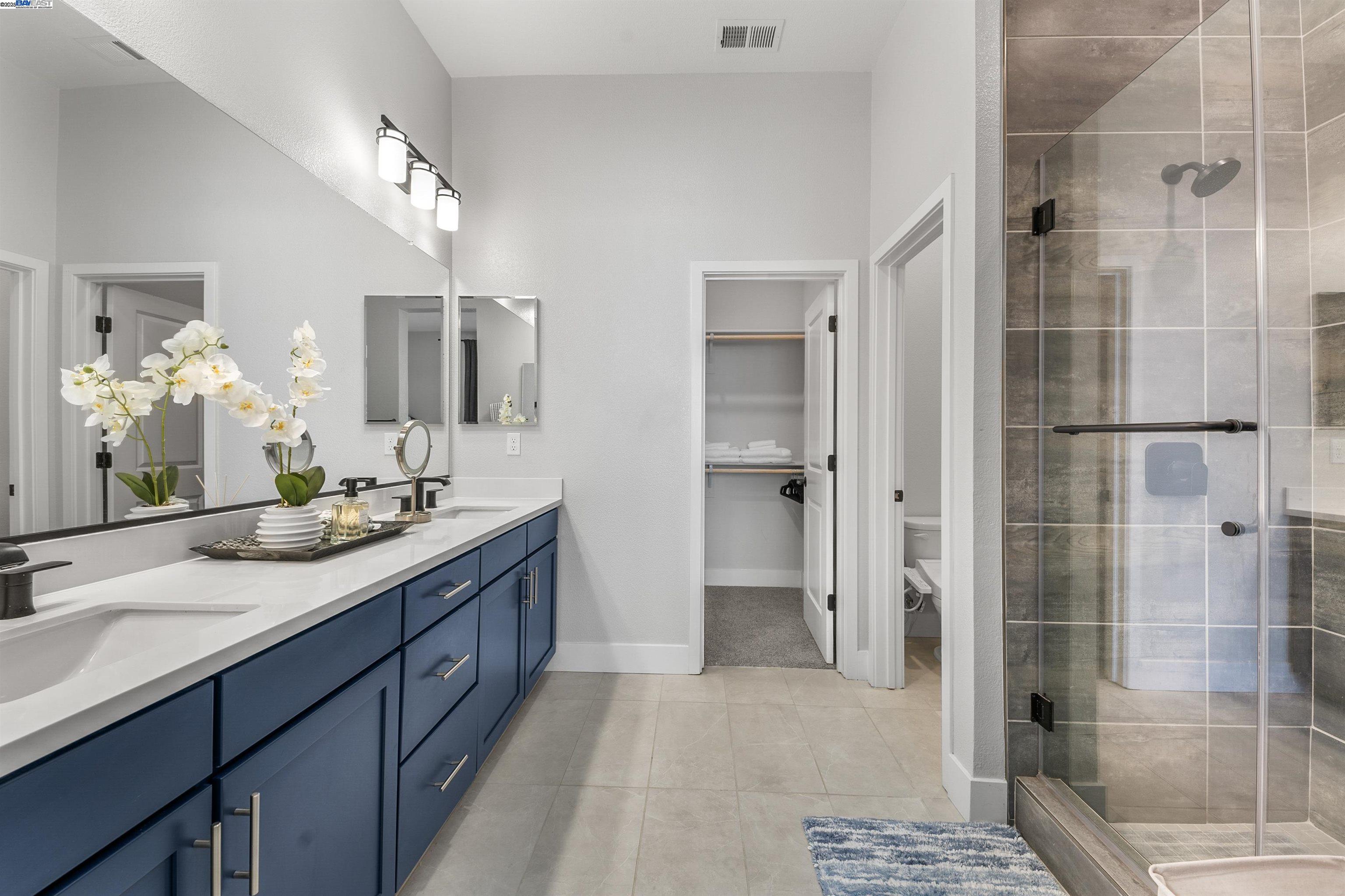 a bathroom with a double vanity sink mirror and shower