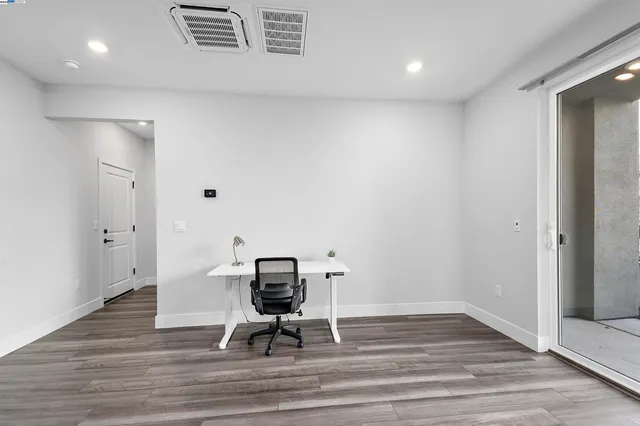 a view of room with wooden floor and furniture