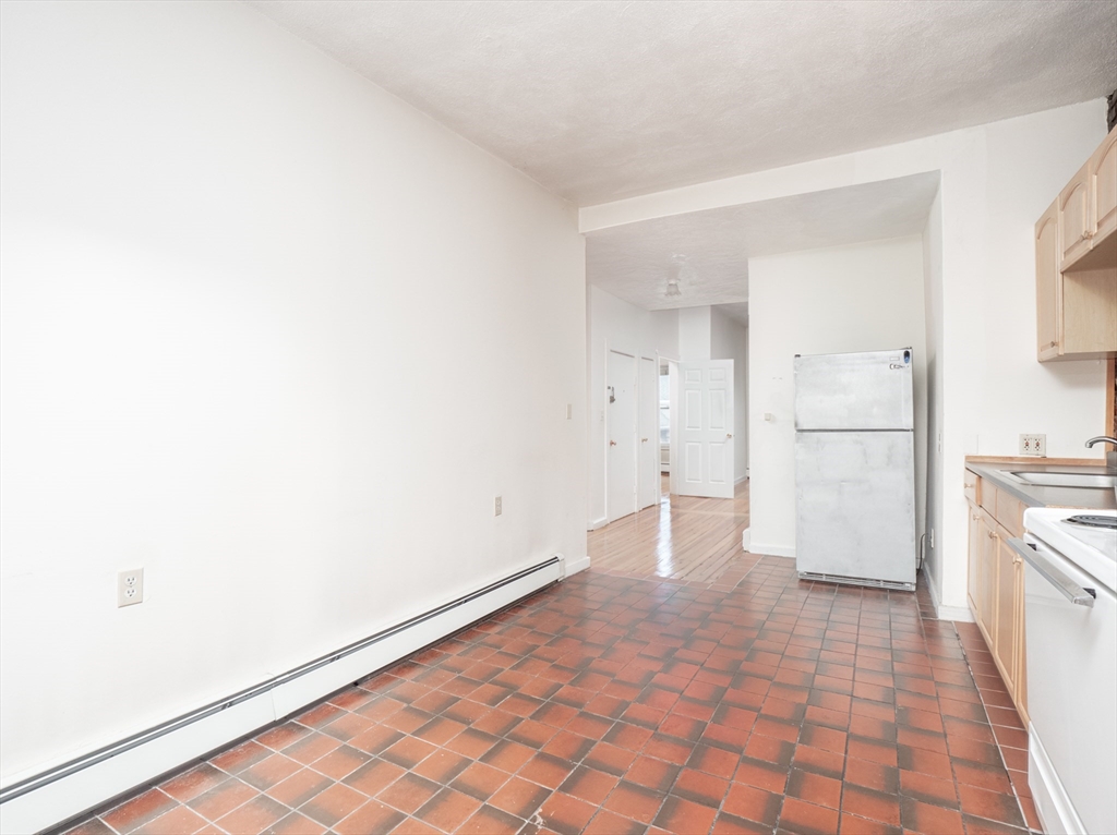 4 Saxton Street Boston, MA 02125 - Photo 11 of 14 a view of empty room with kitchen and window