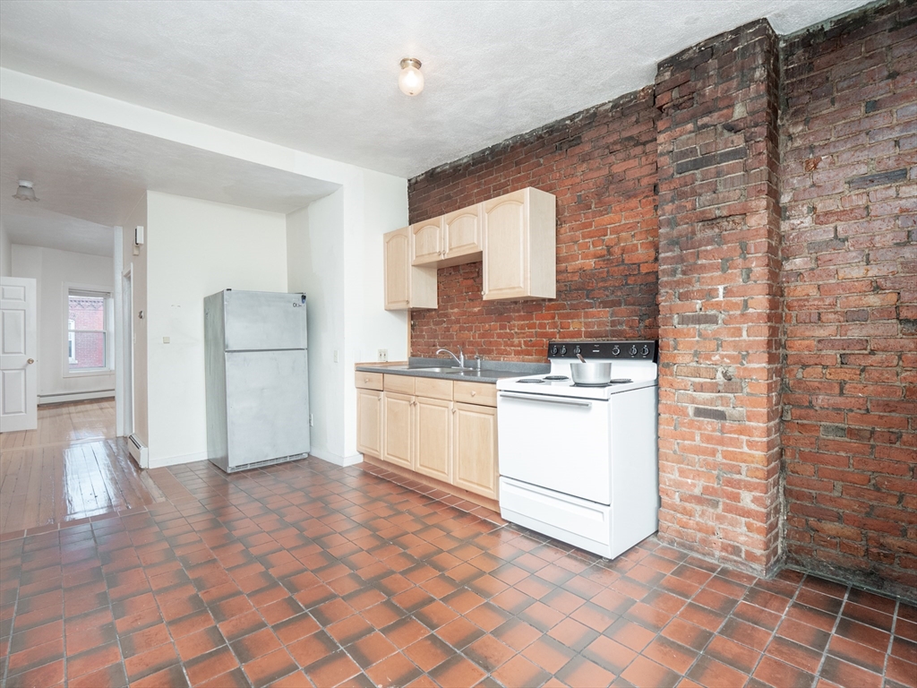 4 Saxton Street Boston, MA 02125 - Photo 12 of 14 a kitchen with stainless steel appliances granite countertop a stove a sink and a refrigerator