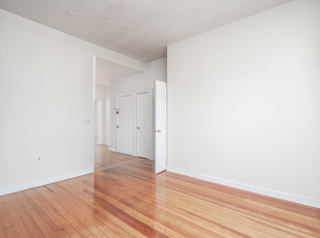 4 Saxton Street Boston, MA 02125 - Photo 7 of 14 a view of an empty room with wooden floor