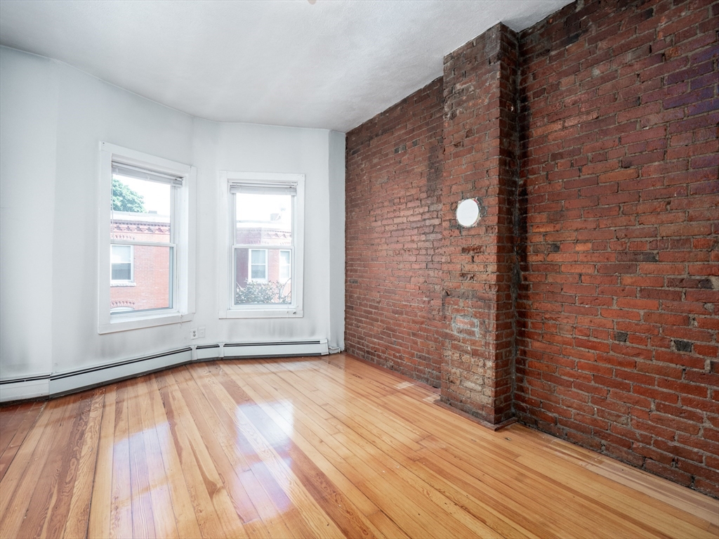4 Saxton Street Boston, MA 02125 - Photo 9 of 14 a view of an empty room with wooden floor and a window