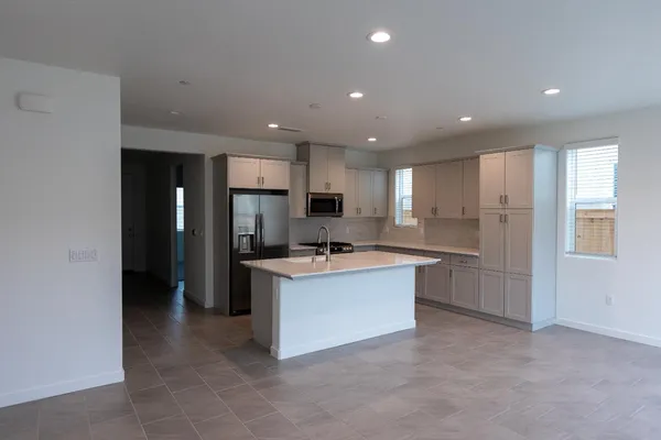 a large kitchen with a sink and a refrigerator