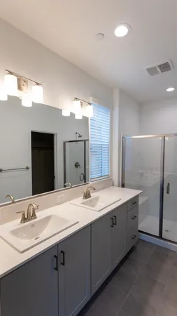 a bathroom with a double vanity sink and a mirror