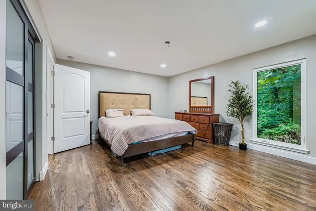 a bedroom with a bed and a large window